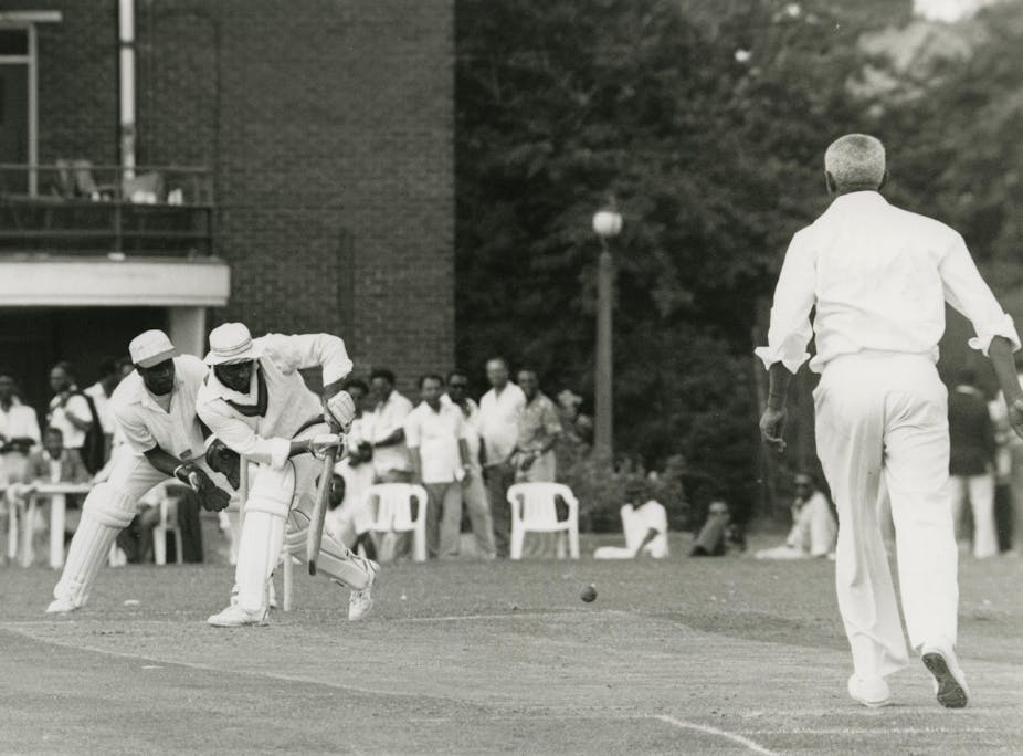 A black and white photograph of black cricketers playing. 