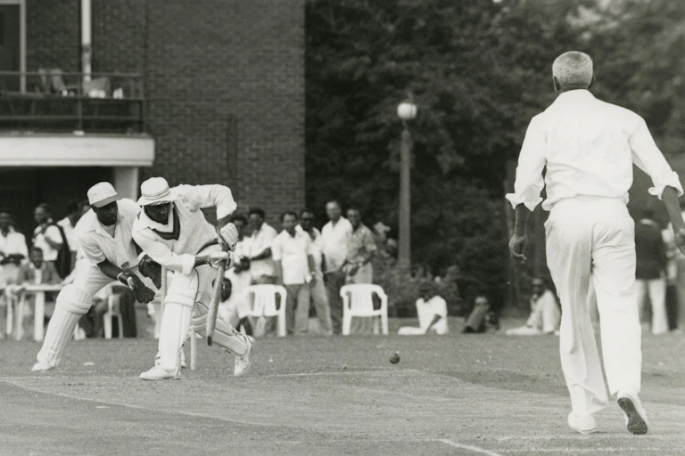 A black and white photograph of black cricketers playing.