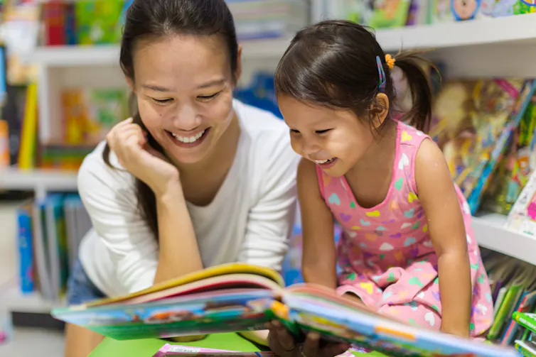 A mother reading a book to child.