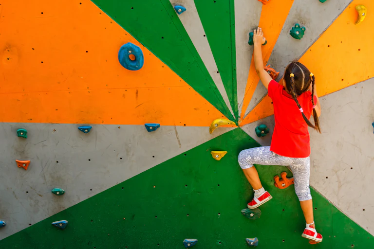 Girl climbs a climbing wall