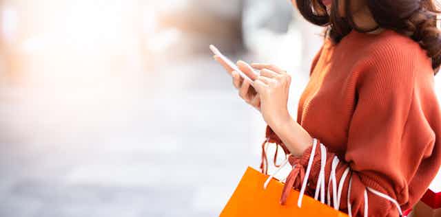 Woman with shopping bags and mobile phone.