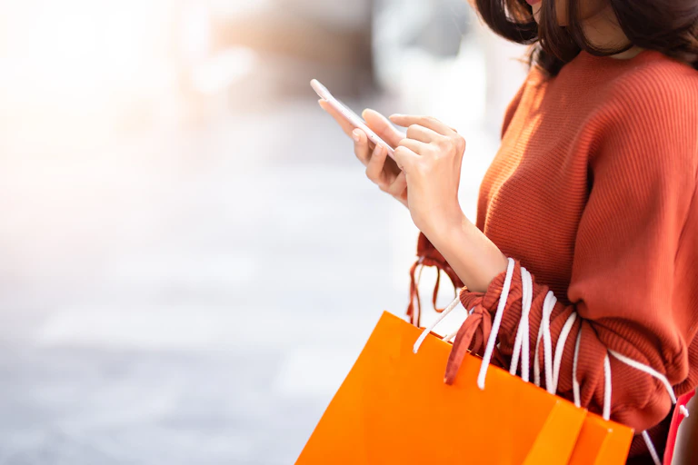 Woman with shopping bags and mobile phone.