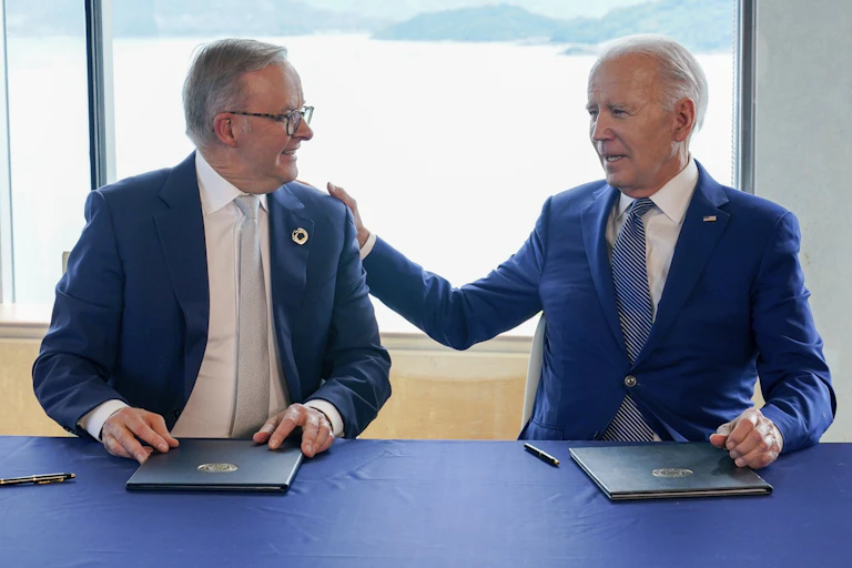two men in suits look at each other