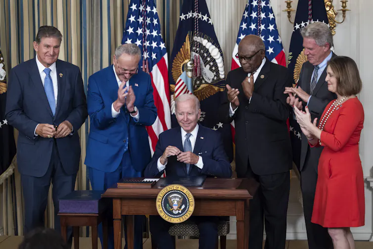 seated man is applauded by colleagues