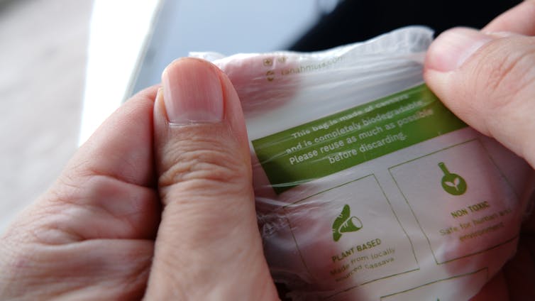 A person holding a biodegradable plastic bag.
