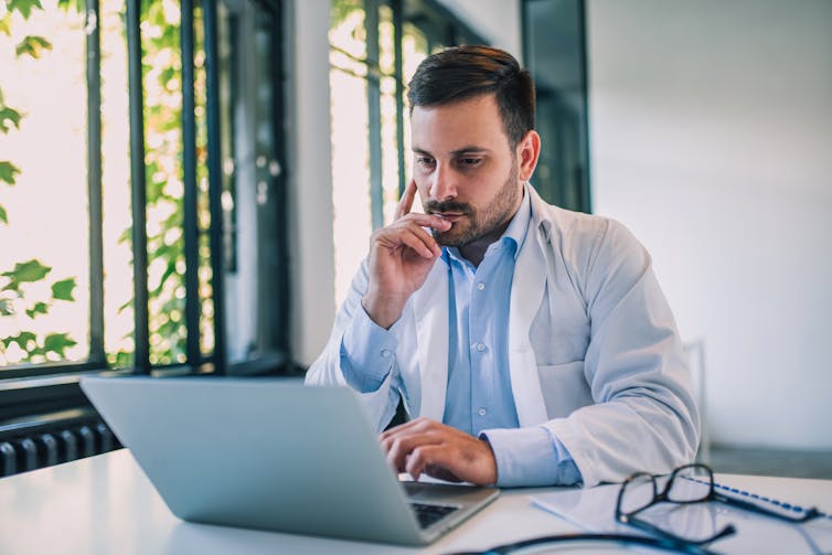 A male doctor at a laptop.