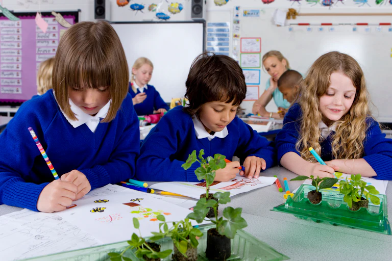 Primary school children in uniform drawing on paper