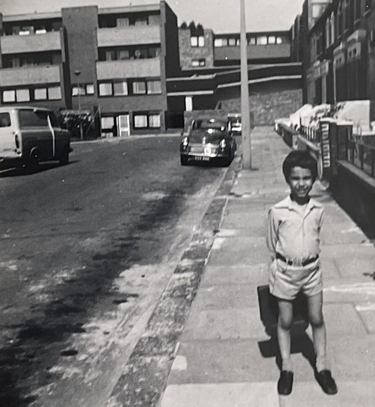 Black and white image of boy standing on a housing estate in the 1970s
