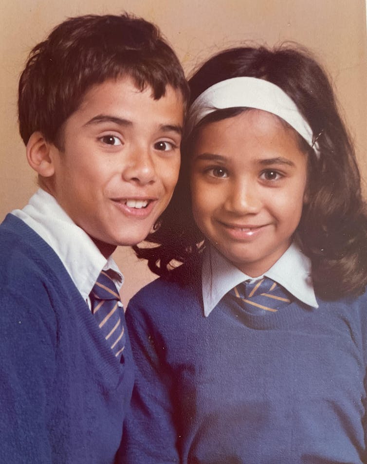 A school photo of a smiling brother and sister.