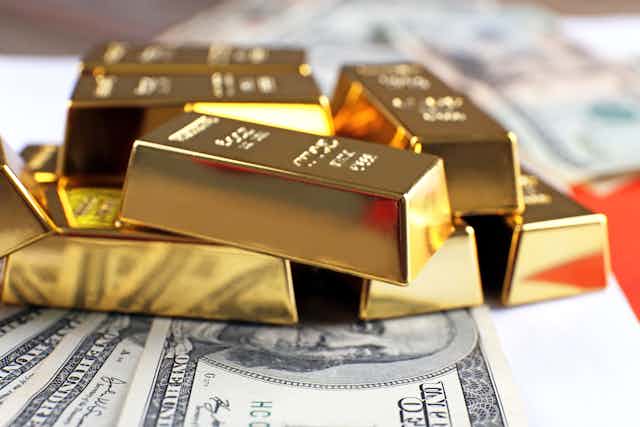 Gold bars piled on top of US dollar notes
