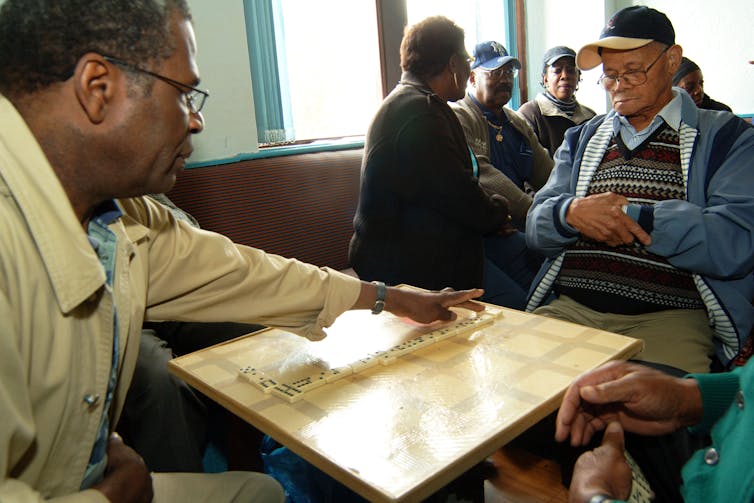 Older men playing dominoes at home.