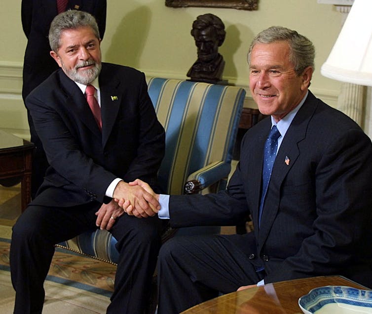 Two men in suits shake hands