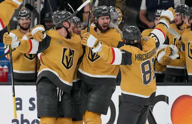 Hockey players celebrating in an ice rink.