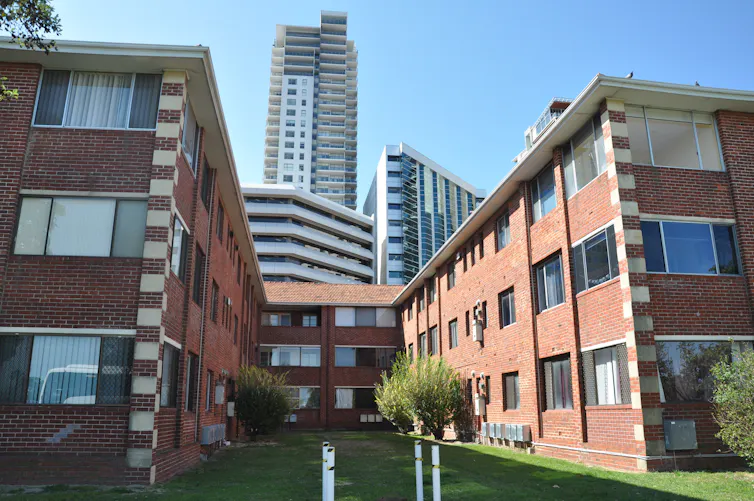 older-style apartment block in front of high rises