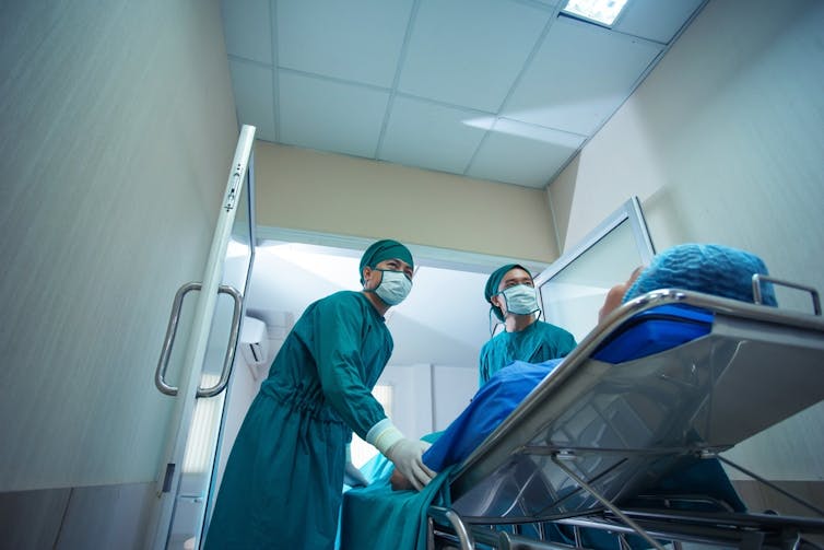 Patient being wheeled on stretcher through hospital corridors