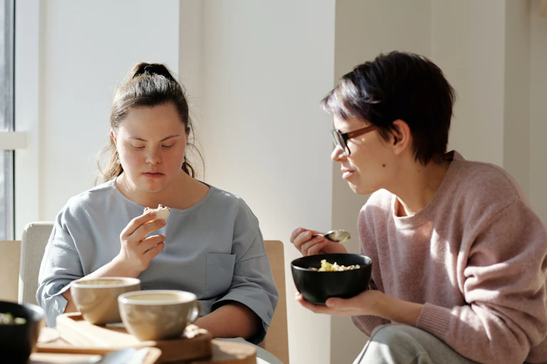 A mother and daughter eat breakfast.