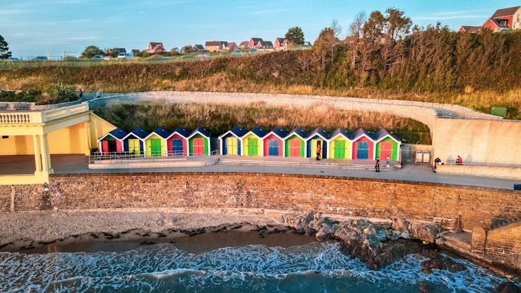 A row of beach huts on a beach.