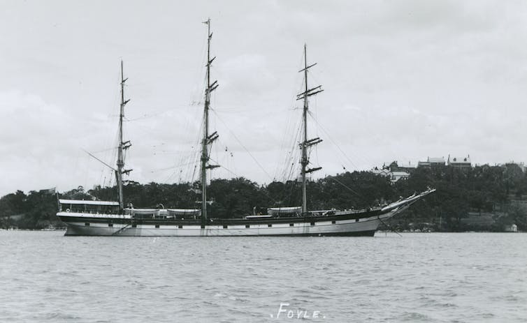 Black and white image of a ship in a harbour.