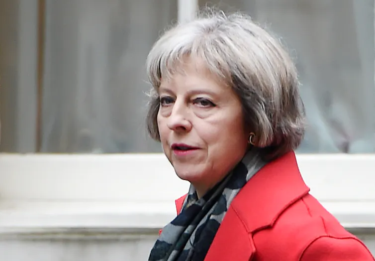 Photo of Theresa May as home secretary, wearing a red jacket