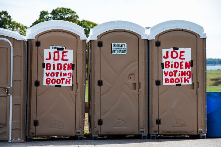 Porta potties with signs reading 'Joe Biden voting booth.'