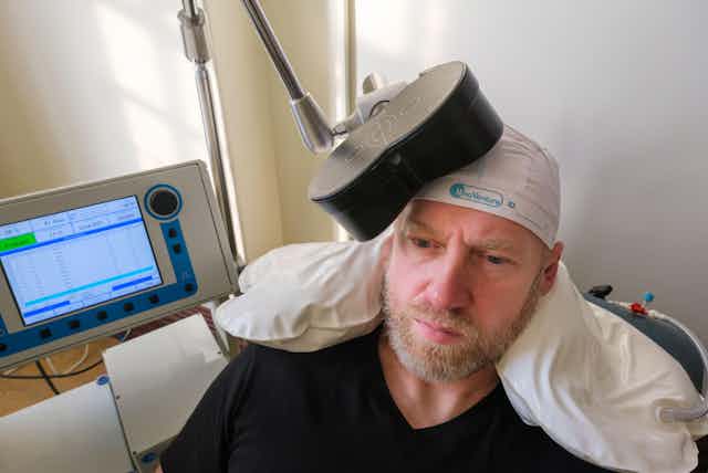 Man receiving transcranial magnetic stimulation