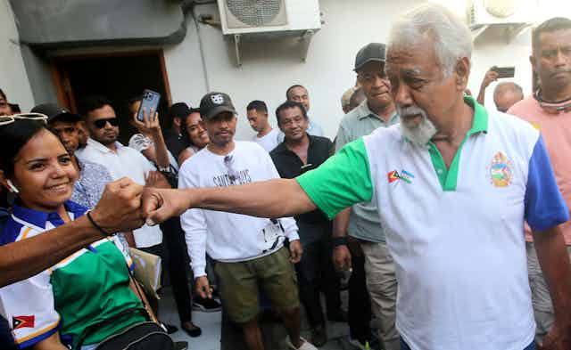 CNRT party leader and former independence fighter, Xanana Gusmao, bumps fifts with a supporter during the 2023 election campaign in East Timor.