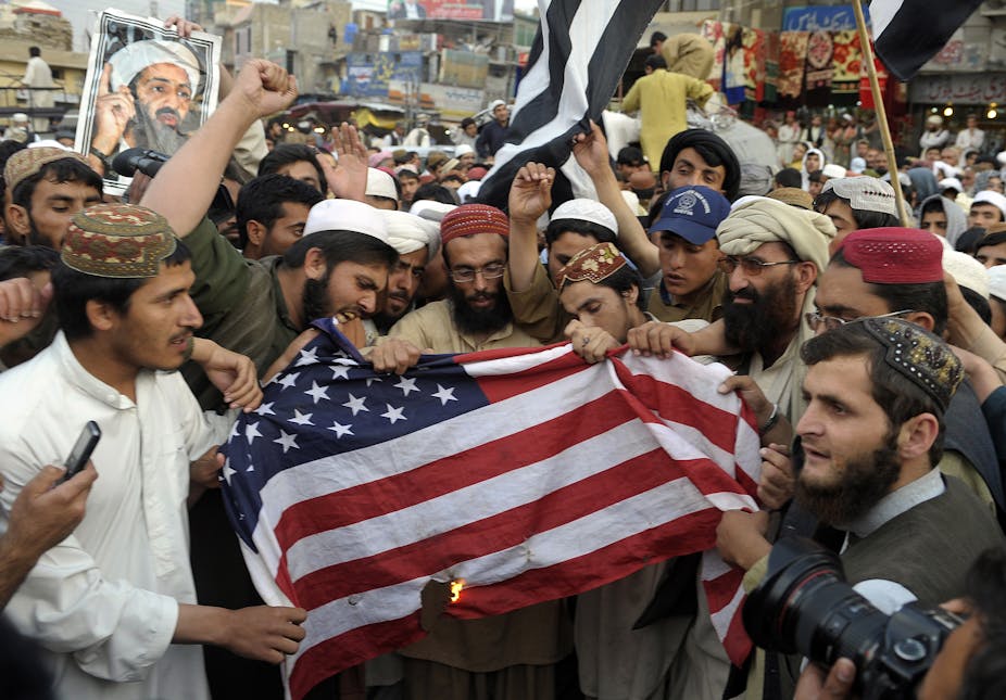 Des manifestants au Pakistan, avec un portrait de Ben Laden, en train de brûler un drapeau américain