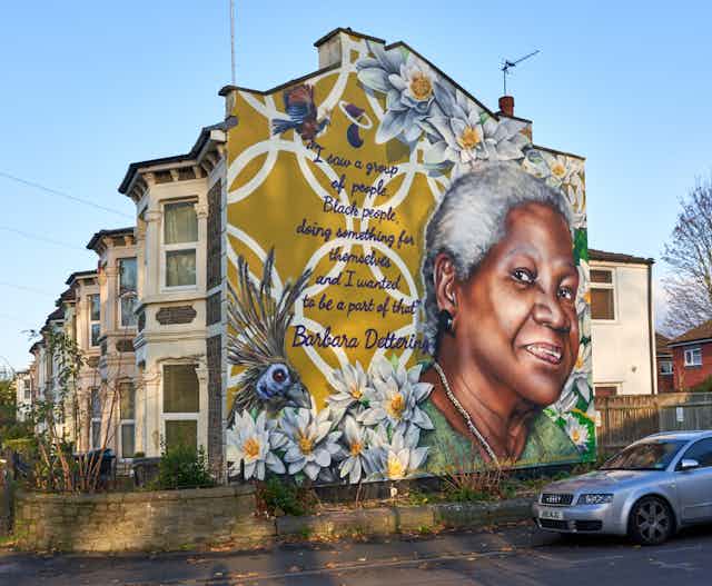 A mural depicting an elderly woman against a background of flowers and text.