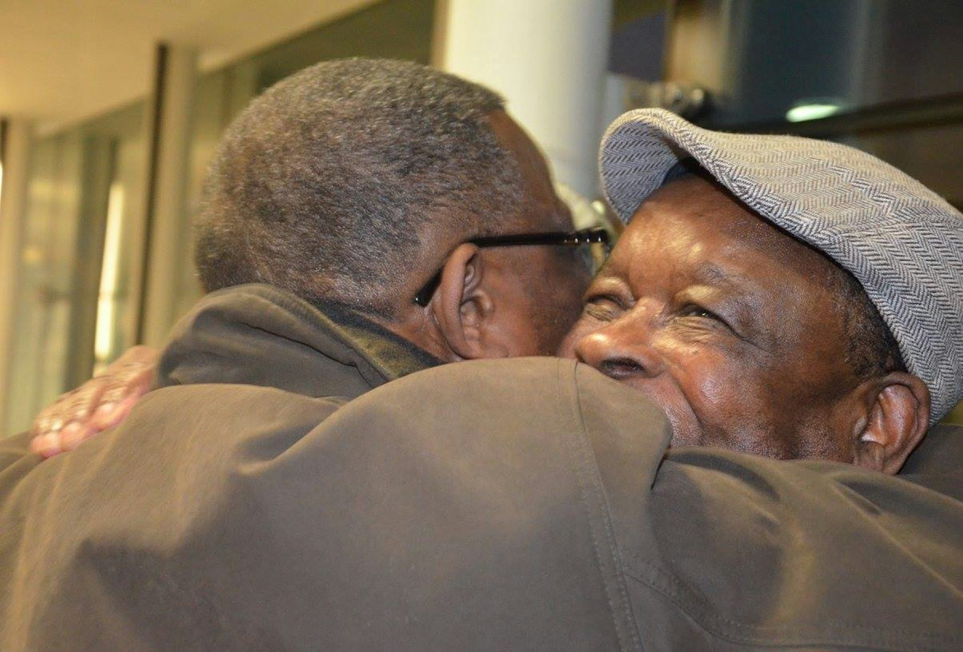 Two old men embrace.