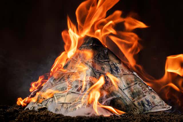 A burning pyramid of bank notes.