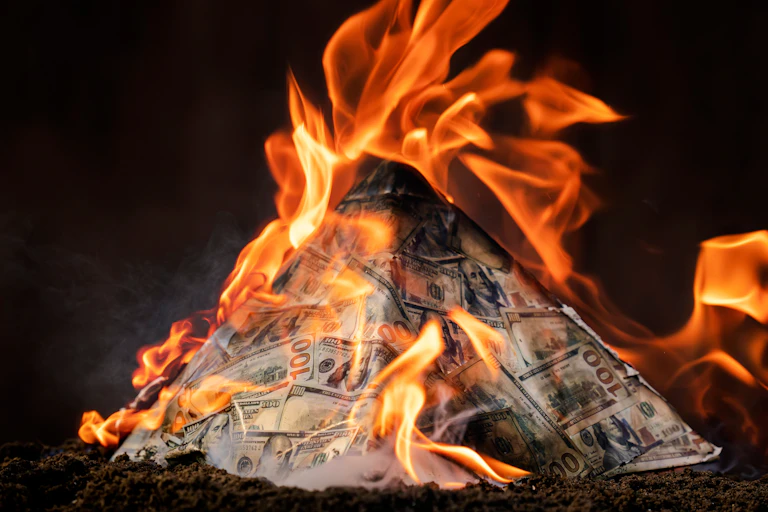 A burning pyramid of bank notes.