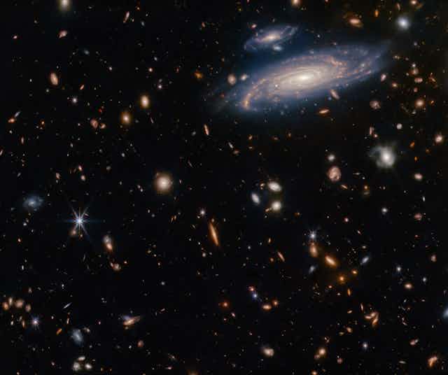 A photo showing many galaxies and stars against a dark background.