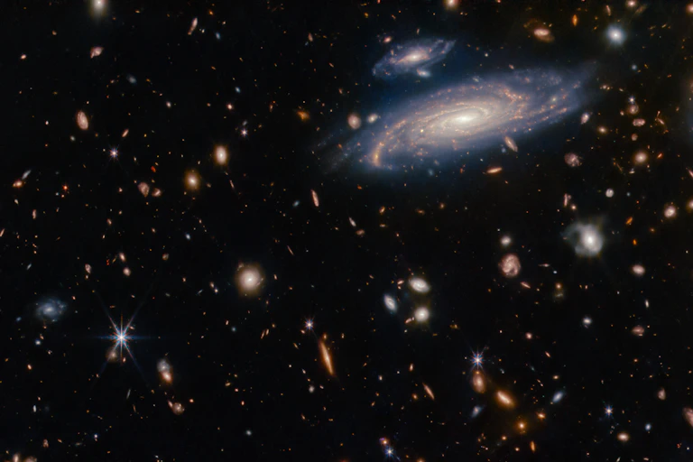 A photo showing many galaxies and stars against a dark background.