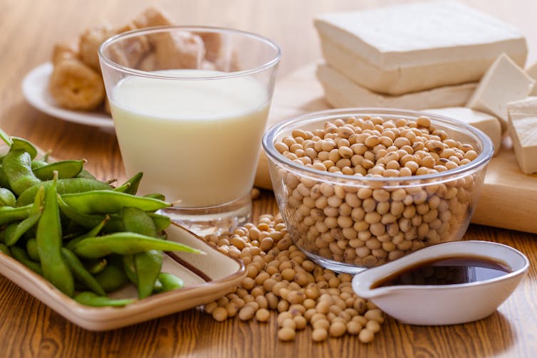 Soy-rich foods on a table: edamame, soy milk, soy sauce