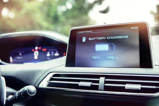 a photograph of an electric car's dashboard showing battery charging at 75%