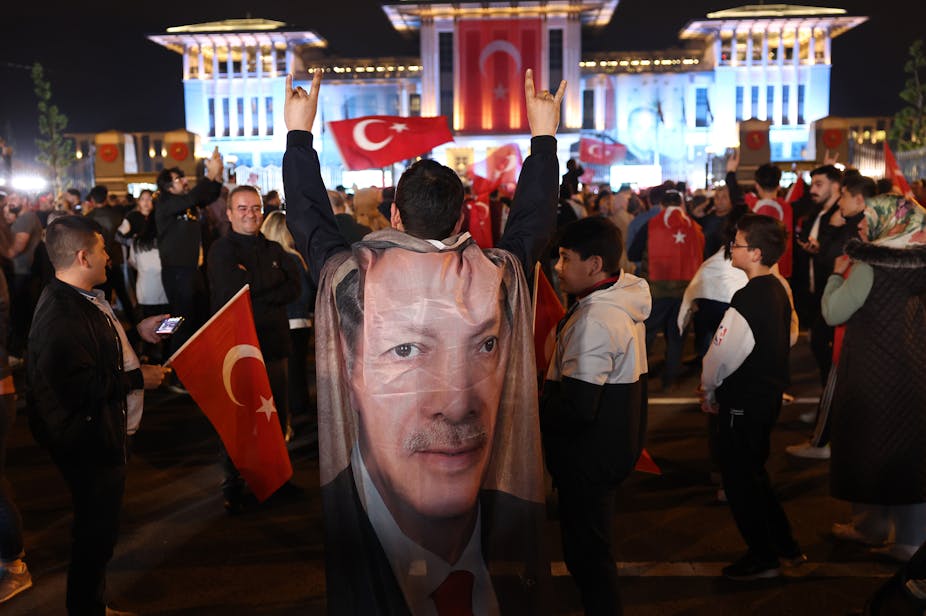 Foule en liesse portant drapeaux turcs et portraits de Recep Tayyip Erdogan.