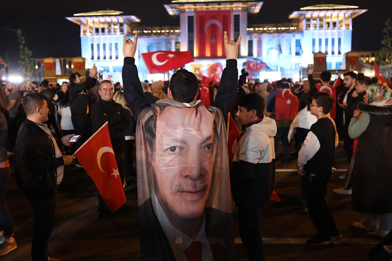 Foule en liesse portant drapeaux turcs et portraits de Recep Tayyip Erdogan.
