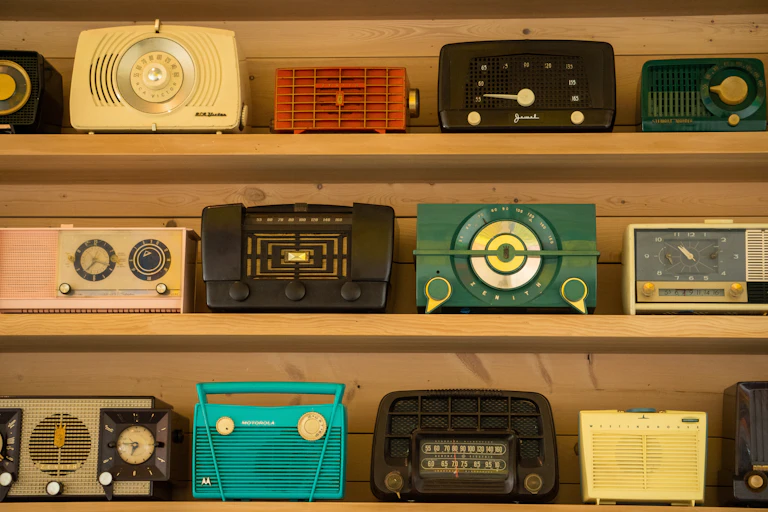 Three shelves of vintage radios.