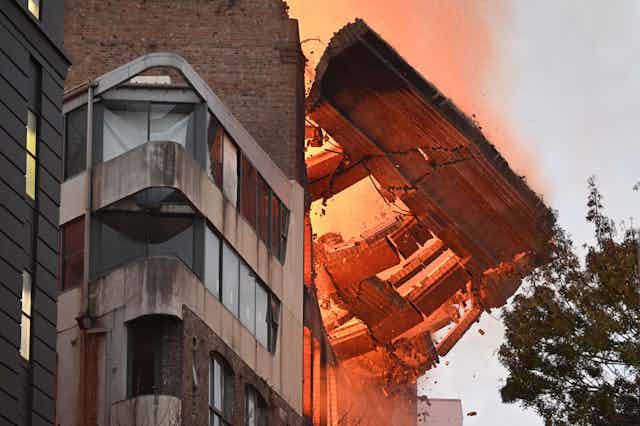 The wall of a building on fire in Sydney collapses