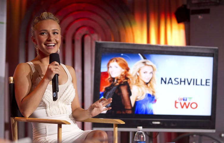 A blonde woman sits in front of a TV screen that says Nashville with the CTV logo at the bottom.