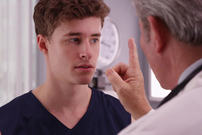 young man with doctor testing his eye tracking