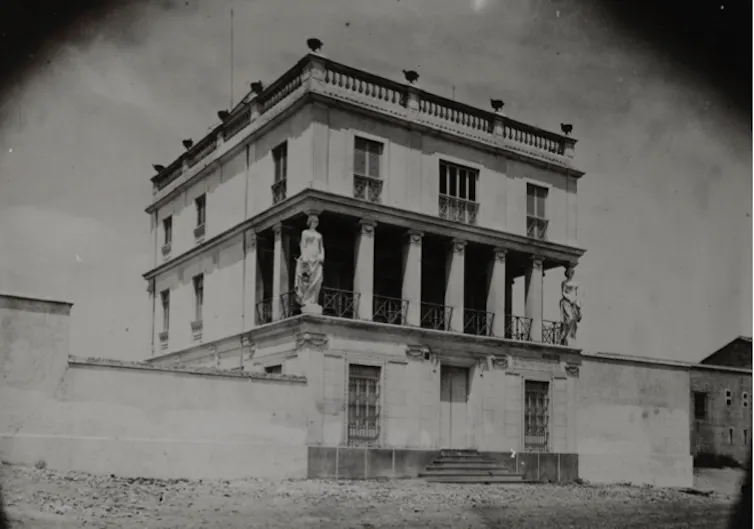 Fotografía en blanco y negro de una casa neoclásica.