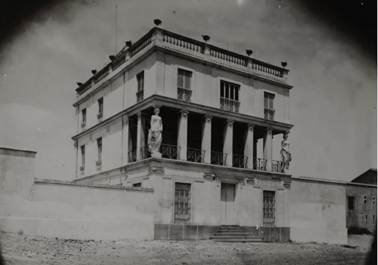 Fotografía en blanco y negro de una casa neoclásica.