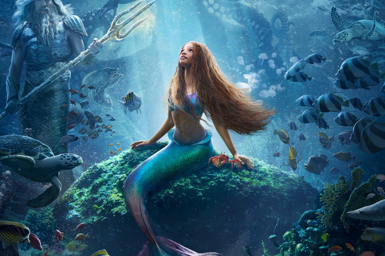 Halle Bailey as Ariel with mermaid tail under the sea.