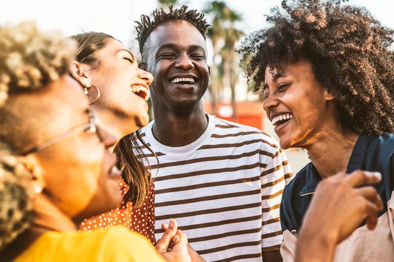 Four young people of university-going age laugh together