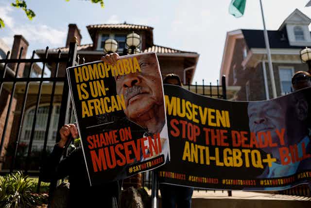 People hold up signs which say "homophobia is un-African"