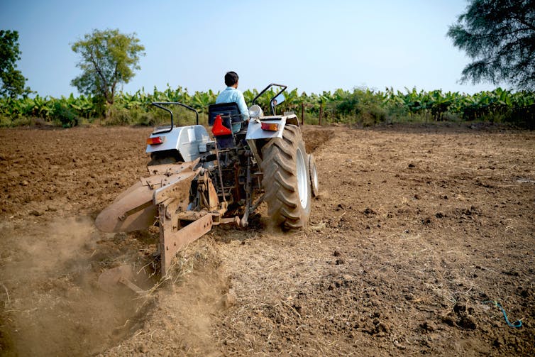 Farmer using a tractor in a field.