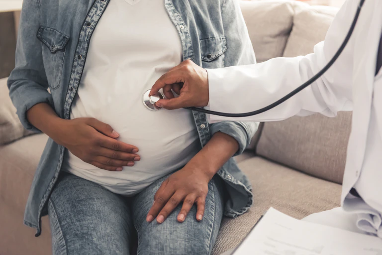 A stethoscope on a pregnant belly