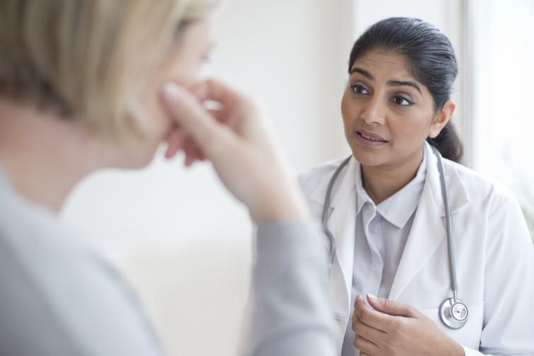 médico falando com paciente e olhando aberto