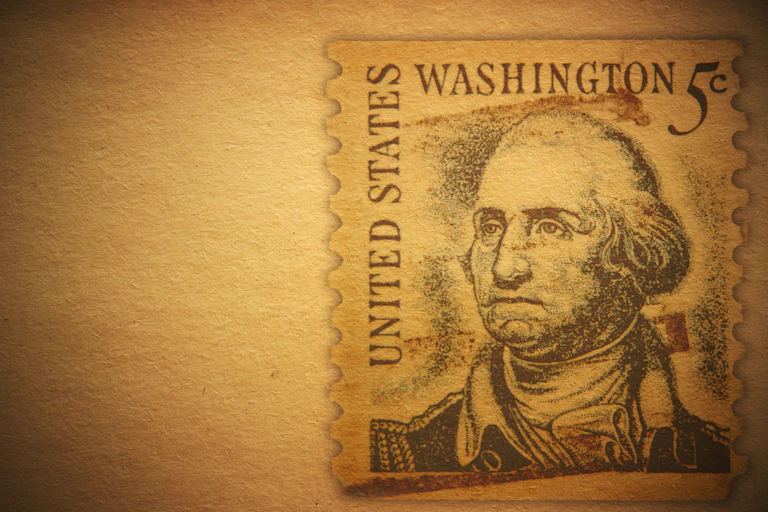 Against an antique brown background: a U.S. postage stamp featuring an image of George Washington.